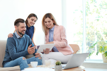 Female real estate agent working with couple in office
