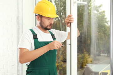 Construction worker installing new window in house