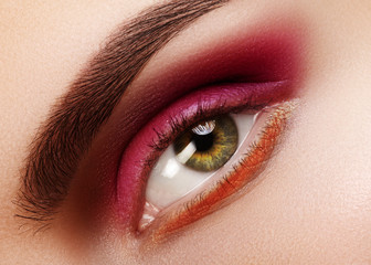 Beauty Close-up Beautiful Female Eye. Celebrate Fashion Make-up with Red Eyeshadows. Christmas or...
