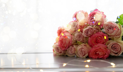 Pile of rose fresh flowers bouquet on gray table with bokeh lights