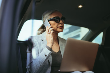 Female entrepreneur working while traveling in a car