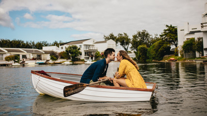 Romantic couple sitting in a boat and kissing