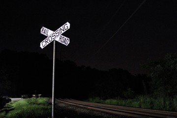 Railroad crossing sign at night.