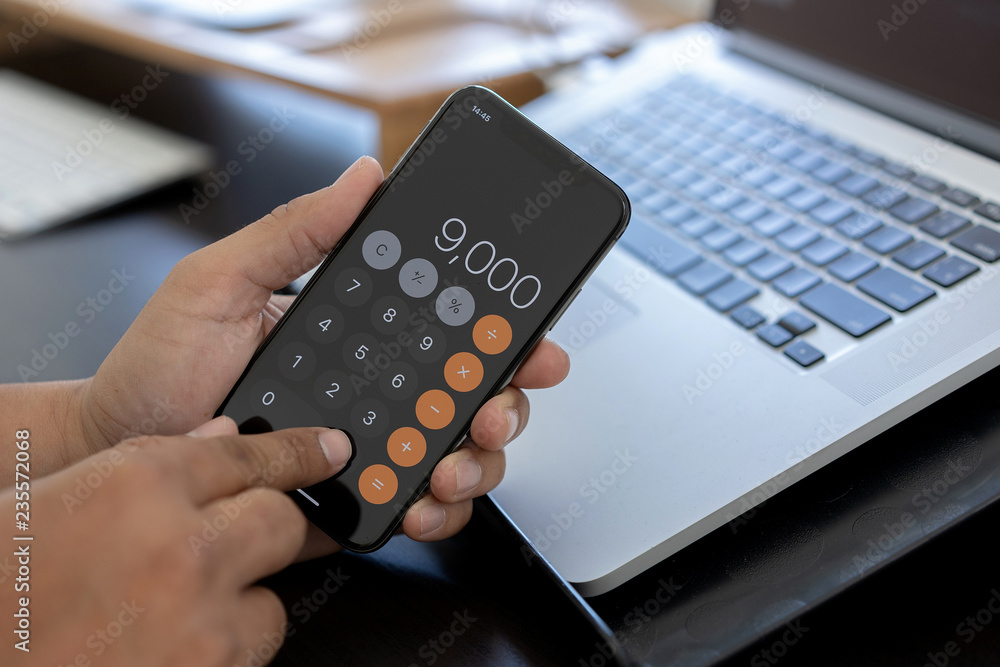 Poster man use calculator make note with calculate about cost in office close up