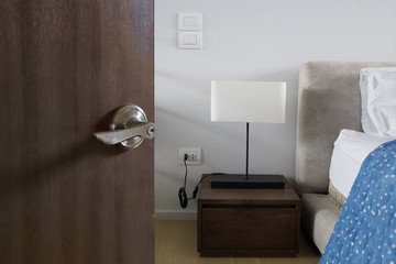 Digital door handle ,hotel or apartment door open in front of bedroom  interior room background, selective focus