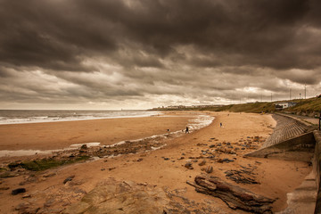 A walk along the coastline of Tynemouth Longsands at Cullercoats Bay near Newcastle, UK