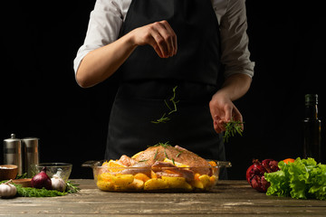 Cooking chef duck sprinkled with rosemary, seasoning, freezing, horizontal photo, black background