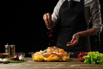 Cooking Peking Duck chef with fruit, on a black background. Horizontal photo, space for menu and design, restaurants, hotel business.