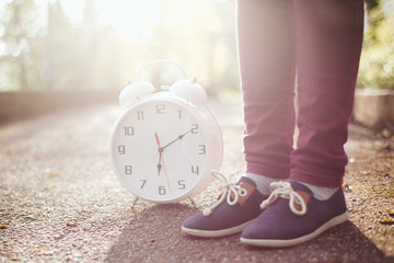 Woman standing next to clock