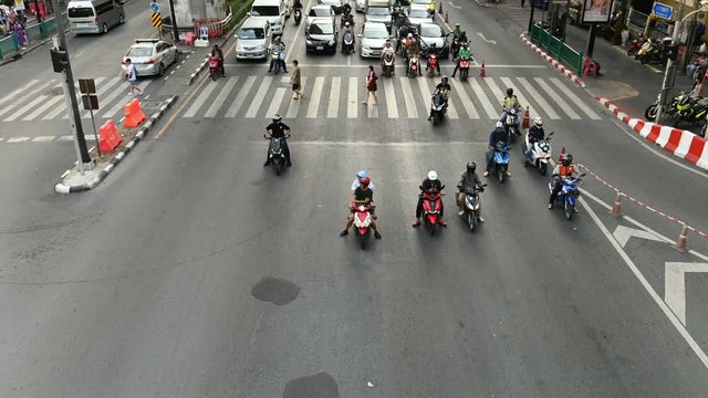 4K Time lapse view of Motorcycles, scooters and mopeds traffic at busy intersection in Bangkok