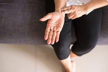 Elderly woman hands checking pulse with two fingers on wrist