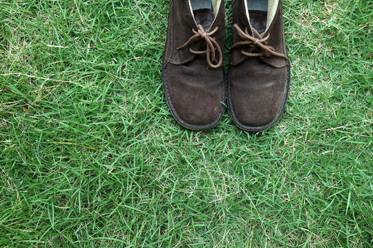 brown boots on green grass background