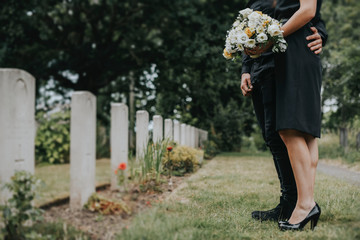 Couple standing together by a gravestone © Rawpixel.com