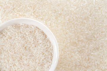 A bowl of rice with rice ears in the background