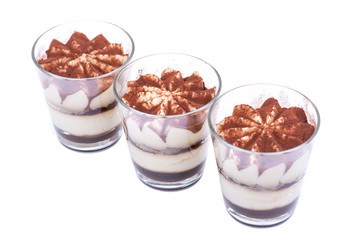 Sweet Italian dessert tiramasu with delicate mascarpone cream from traditional recipe in glass isolated on white background