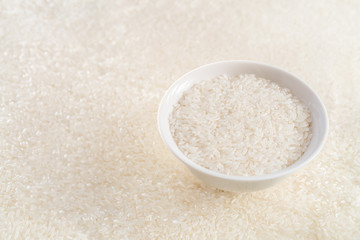 A bowl of rice with rice ears in the background