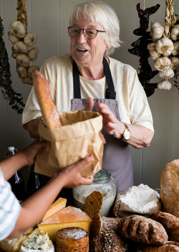 Elderly woman selling bread at a deli shop