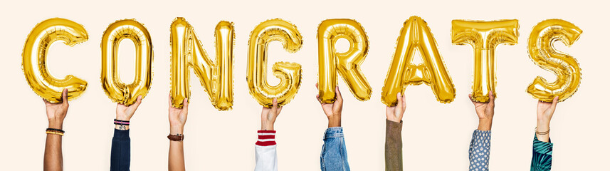 Yellow gold alphabet balloons forming the word congrats