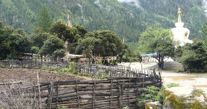 4k tibet people walking around buddhist white stupa in village,cloud cover mountain.