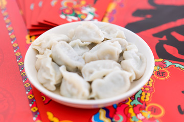 A dish of dumplings under the background of red couplets during the Spring Festival