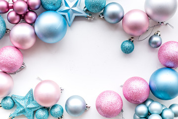 Christmas and New Year symbols. Toys for festive tree. Blue and pink balls and stars on white background top view copy space frame