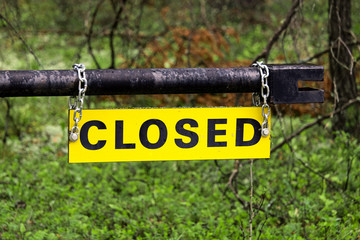 A yellow closed sign on an metal gate