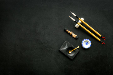 Accessories for chinese or japanese calligraphy. Special writting pen, ink on black background top...