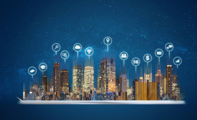 Digital tablet with modern buildings hologram and technology icons. Smart city,  internet and...