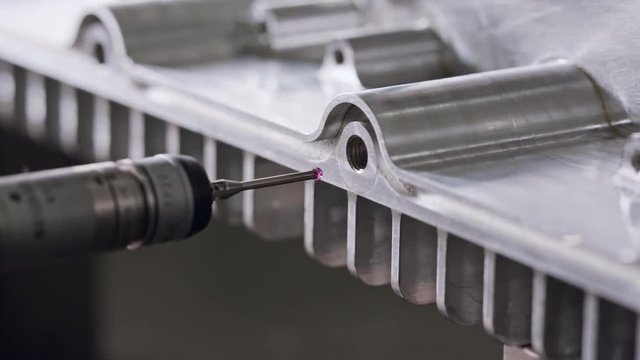 Macro footage of a coordinate measuring machine CMM measuring metal part