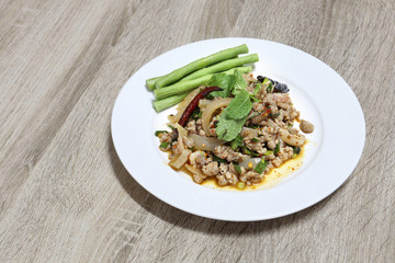 Spicy minced pork salad thai tradition food on wooden background with copy space
