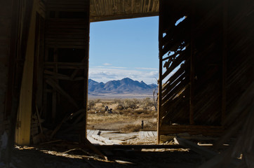 The mountain parks through the doorway of the old empty home in the great basin. 