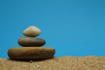 Fototapeta na wymiar A cairn or Zen pile of pebbles on sea sand.