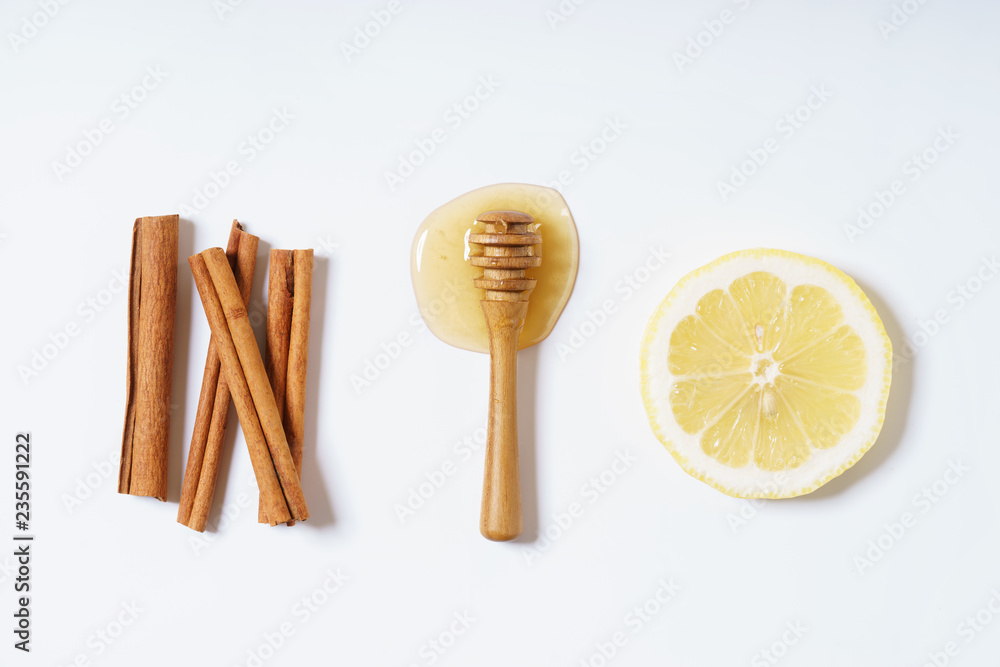 Wall mural lemon, honey and cinnamon sticks on white background