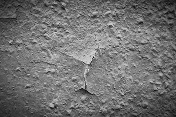 grey peeling paint on the old rough concrete surface . black and white view with vignette