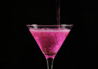 pink cocktail in a glass on a dark background