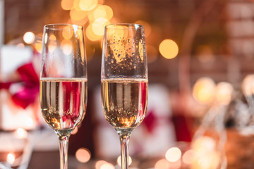 Two champagne glasses in front of christmas presents