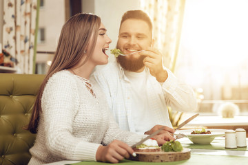 Happy man and woman have lunch in a restaurant