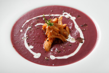 Close up of red cream soup with squid dish