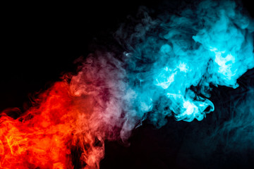 Fototapeta premium A background of blue, red and green wavy smoke in the shape of a ghost's head or a man of mystical appearance on a black isolated ground. Bright abstract pattern of steam from vape.