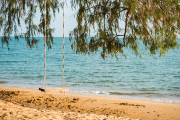 scenery background swing under tree by beach with beautiful sea