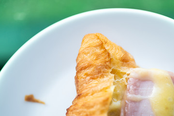 Croissant ham cheese, France food in plate on table.