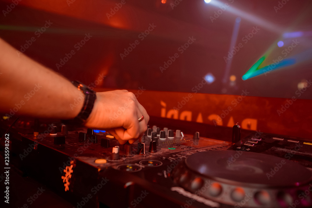 Wall mural control dj for mixing music with blurred people dancing at party in nightclub