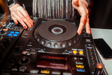 Obraz premium DJ mixer on the table background the night club and dancing people