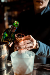 Expert Bartender is making cocktail at bar.