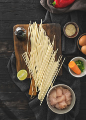 Raw ingredients cooking udon noodles chicken meat dark top view