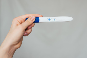Obraz premium positive pregnancy test in the hands of a girl close-up
