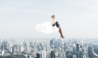 Fototapeta na wymiar Businesswoman or accountant on cloud floating high above modern city