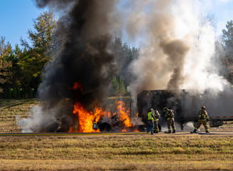 Fototapeta na wymiar Firefighters extinguishing semi truck flames on highway; traffic blockage; 911 emergency