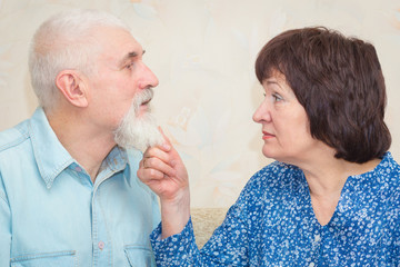 A woman holds a man by his beard.