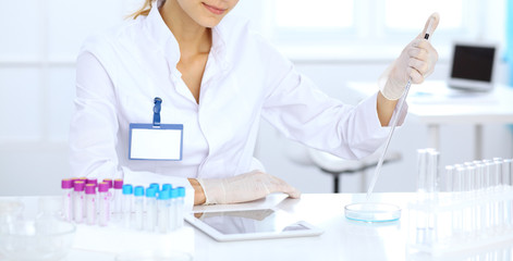 Female scientific researcher or blood test assistant at work in laboratory. Science, medicine and pharmacy concept